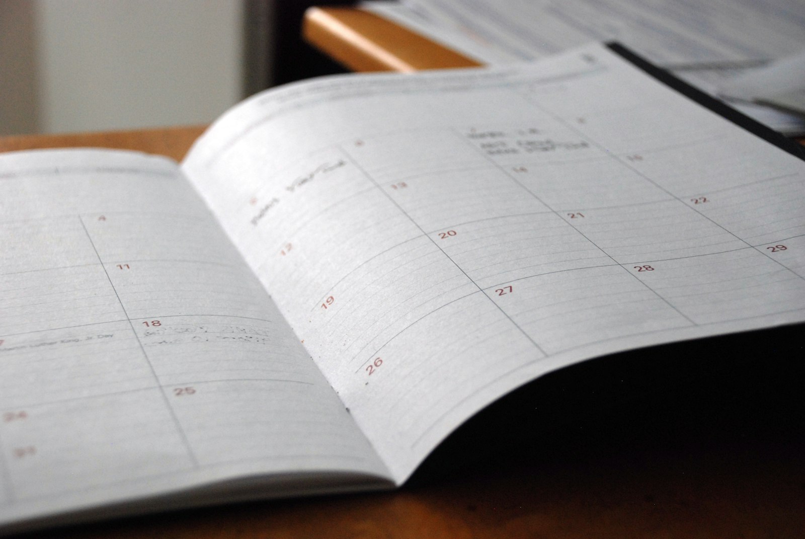 Open monthly planner on a wooden desk, ready for planning a licensing timeline
