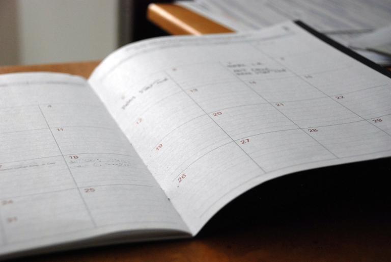 Open monthly planner on a wooden desk, ready for planning a licensing timeline